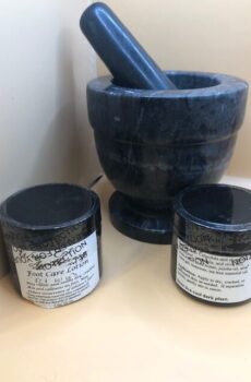 Two amber glass jars in front of a mortar and pestle.